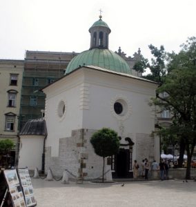 Kościół świętego Wojciecha Biały budynek, częściowo kamienny. Dach zielony, miedziany o krztałcie kopuły. Na kopule niewielka wieżyczka z krzyżem. Na każdej ze ścian po jednym okrągłym oknie.