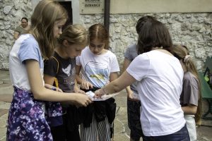 Grupa dzieci w muzealnym ogrodzie podczas gry terenowej - znajdź skarb - oferta wakacyjna