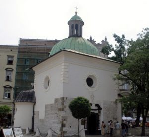 Kościół świętego Wojciecha Biały budynek, częściowo kamienny. Dach zielony, miedziany o krztałcie kopuły. Na kopule niewielka wieżyczka z krzyżem. Na każdej ze ścian po jednym okrągłym oknie.